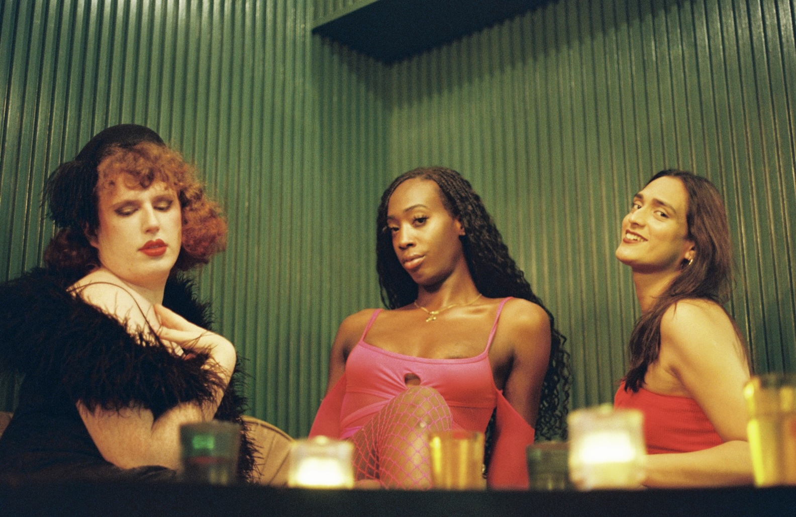 three women sit at Three Dollar Bill against a green backdrop